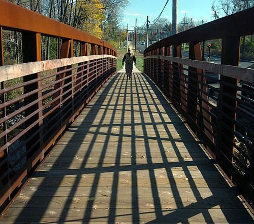 A worker crosses the new pedestrian bridge spanning the Wissahickon Creek next to Sumneytown Pike. The bridge was installed as part of the road widening project in Upper Gwynedd in 2009. (MediaNews Group file photo)