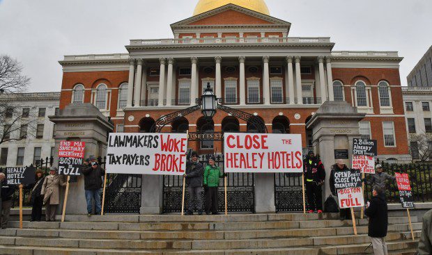 Boston, MA - March 27, 2024: People stand out at the State House in protest to housing migrants.(Chris Christo/Boston Herald)