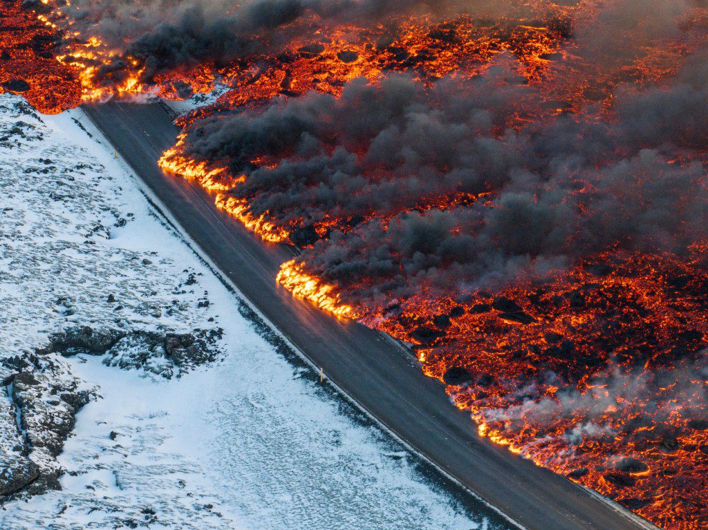 A view of lava crossing the main road to Grindav??k and flowing on the road leading to the Blue Lagoon, in Grindav??k, Iceland, Thursday, Feb. 8, 2024. A volcano in southwestern Iceland has erupted for the third time since December and sent jets of lava into the sky. The eruption on Thursday morning triggered the evacuation the Blue Lagoon spa which is one of the island nation???s biggest tourist attractions. (AP Photo /Marco Di Marco)