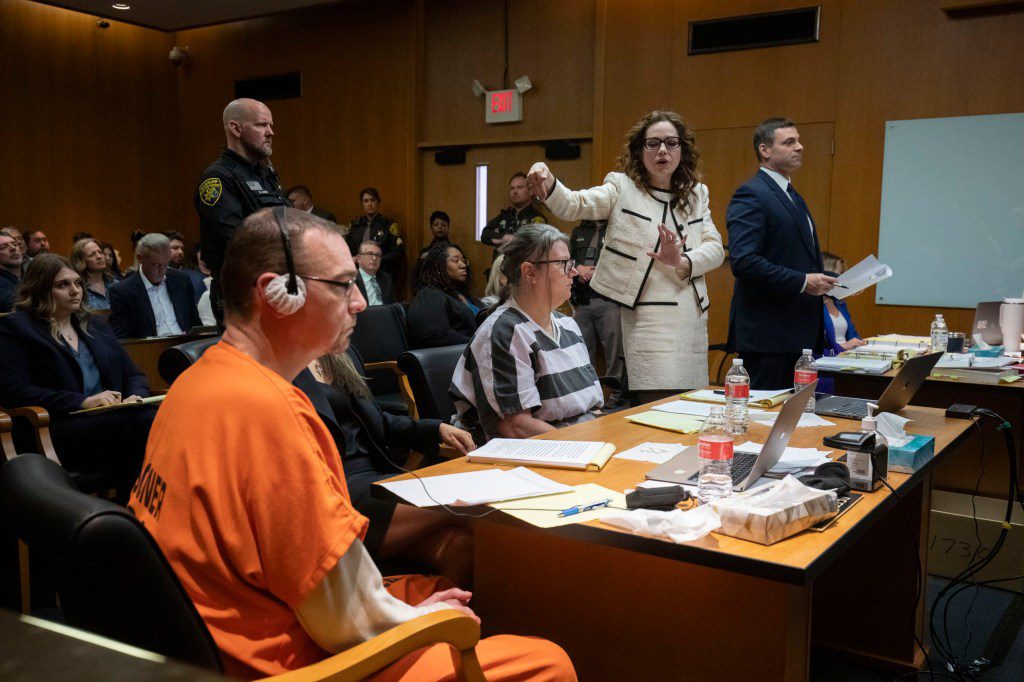 James Crumbley (left) and his wife Jennifer Crumbley (third from right) await their sentencing in  Oakland County Circuit Court on Tuesday 