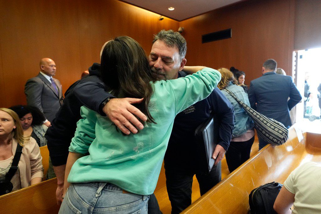 After victim impact statements in the sentencing hearing, Buck Myre hugs Reina St Juliana, Hana St Juliana's sister
