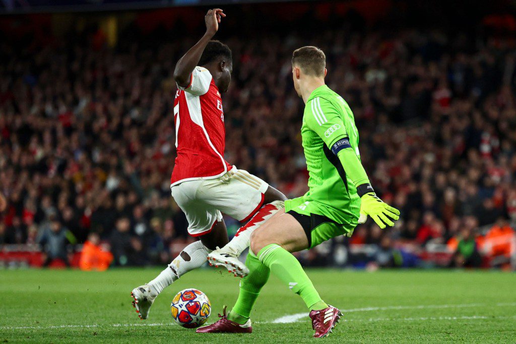 Bukayo Saka of Arsenal is challenged by Manuel Neuer of Bayern Munich in the penalty area Arsenal v Bayern Munich