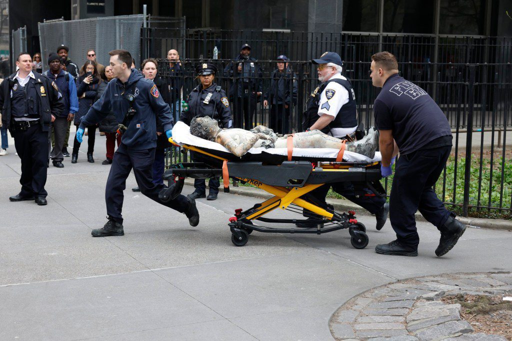 Paramedics attend to a person who lit themselves on fire near Manhattan Criminal Court