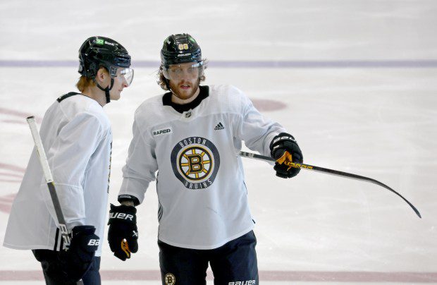 Bruins center Danton Heinen, left, gets some pointers from right wing David Pastrnak during Friday's practice. (Staff Photo/Stuart Cahill/Boston Herald)
