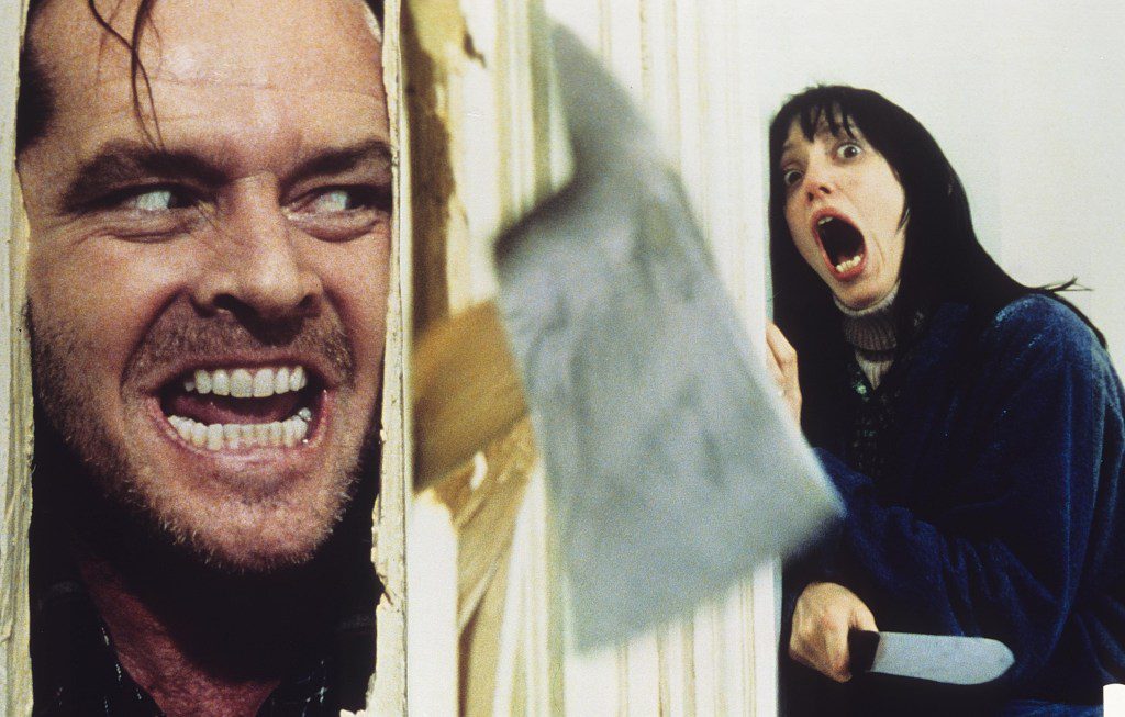 Jack Nicolson breaks through door with axe in the Shining as Shelley Duvall screams