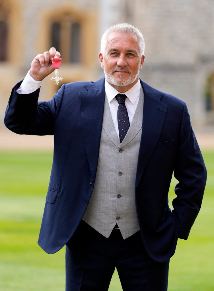 Paul Hollywood holding his MBE medal.