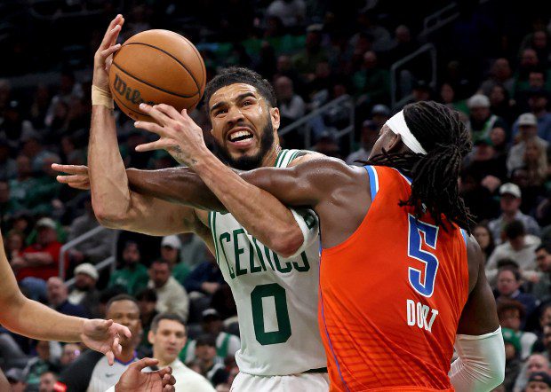 Boston Celtics forward Jayson Tatum is fouled by Oklahoma City Thunder guard Luguentz Dort during Boston's victory in Boston. (Staff Photo/Stuart Cahill/Boston Herald)