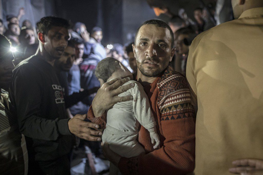 An injured Palestinian baby is being taken by a man to Kuwait Hospital for treatment in Rafah, Gaza on April 4.