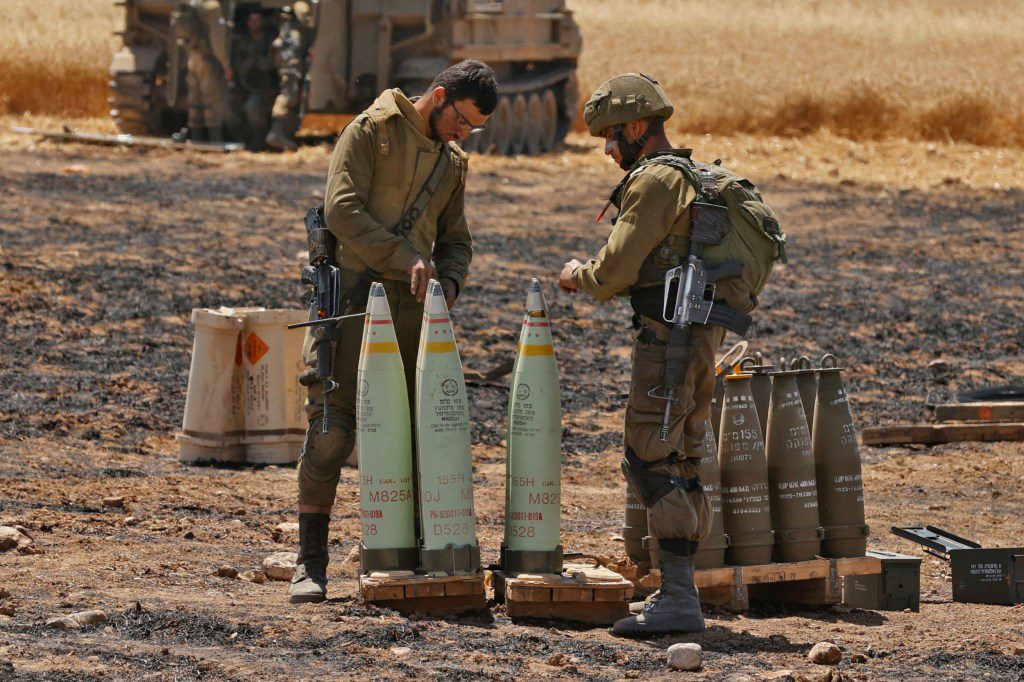 Israeli soldiers prepare to fire artillery shells towards the Gaza Strip from their position near the southern Israeli city of Sderot