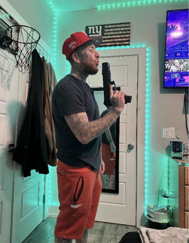 This photo shows accused gun trafficker Scott Grondin posing with Keltec PMR-30 .22-caliber pistol inside his Philadelphia residence. (Photo courtesy Montgomery County District Attorney)